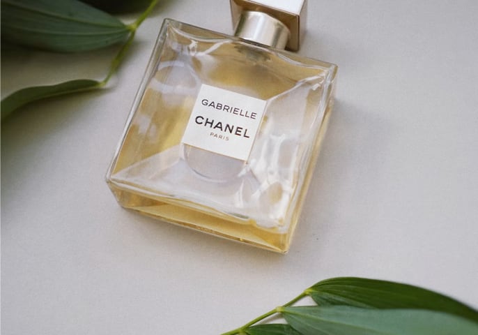 Gabrielle Chanel Perfume bottle surrounded by leaves